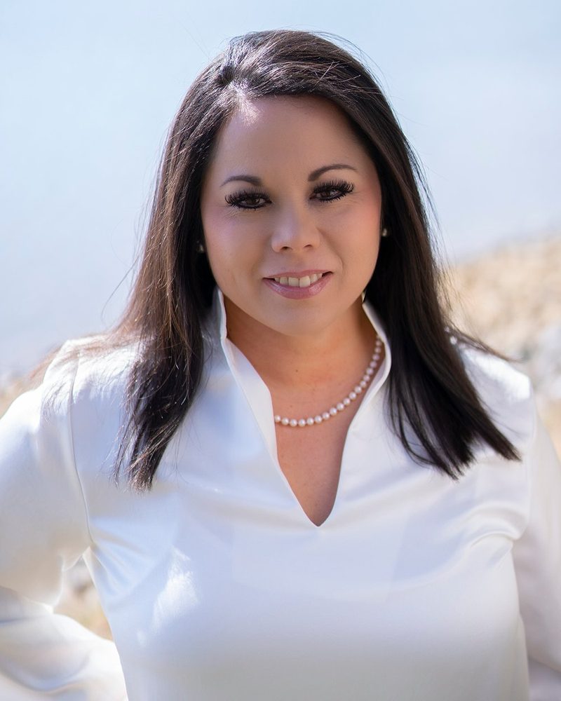 Cherie Garcia outdoors in a white blouse and pearls